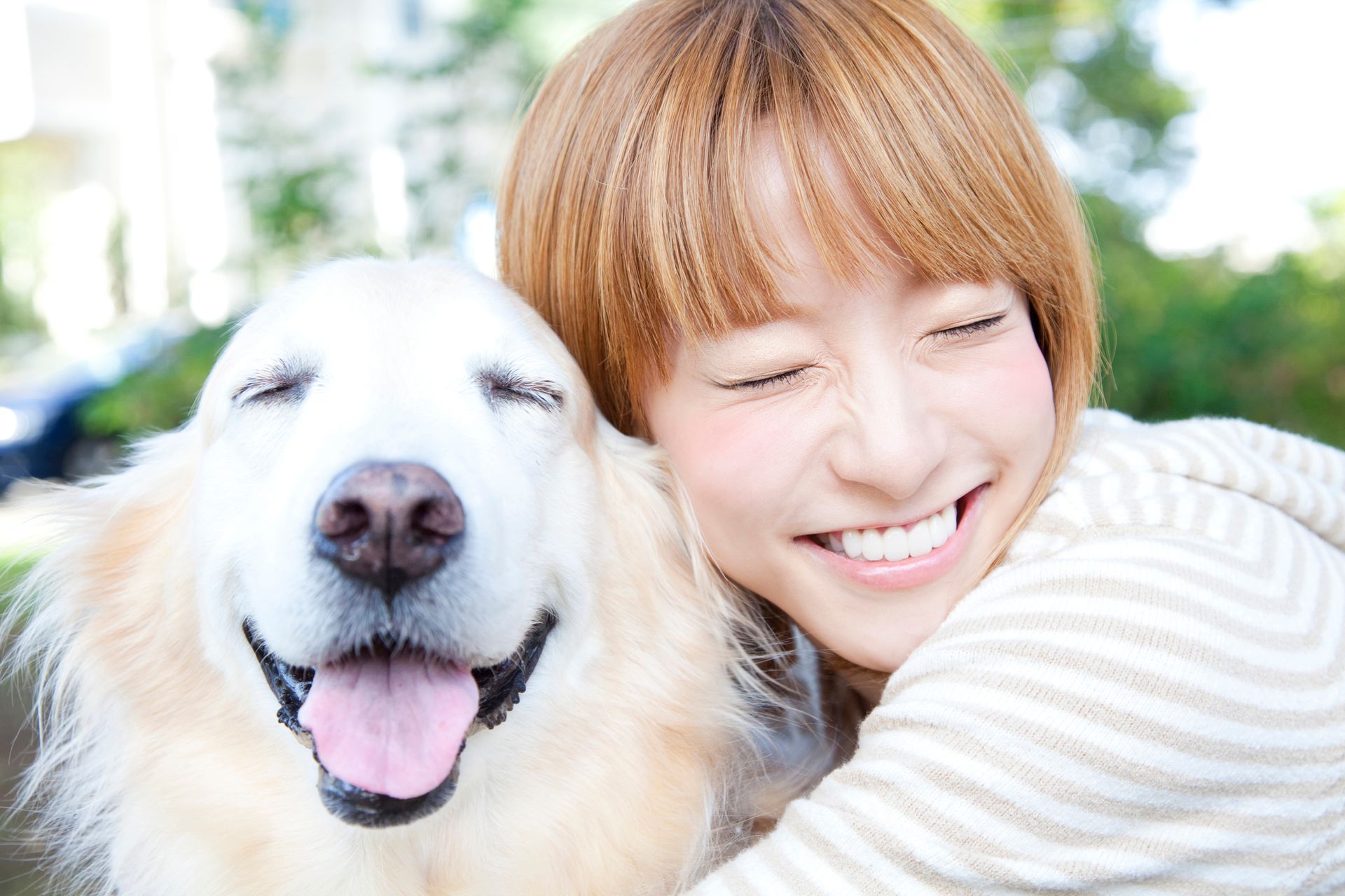 愛犬を抱きしめて笑う女性
